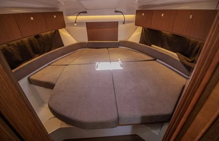  Yacht Photos Pics 2021 Beneteau Antares cabin interior with cozy seating and wooden accents.