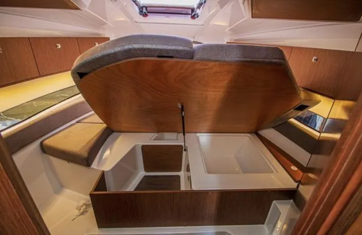  Yacht Photos Pics 2021 Beneteau Antares interior cabin with wooden finish and storage compartments.