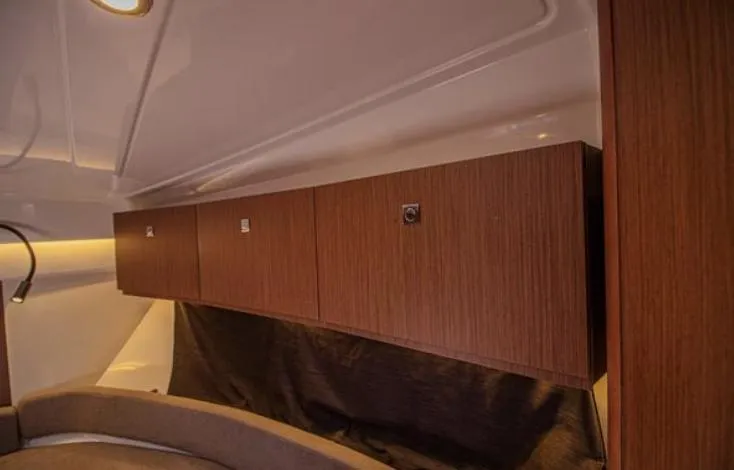  Yacht Photos Pics Interior of 2021 Beneteau Antares boat with wooden cabinets and cozy seating area.