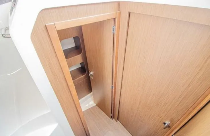  Yacht Photos Pics 2021 Beneteau Antares interior wooden cabinet with open door and shelves.