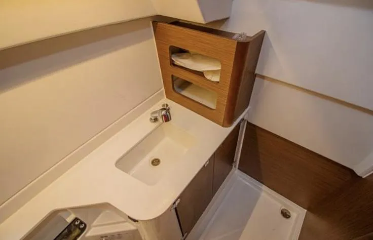  Yacht Photos Pics 2021 Beneteau Antares bathroom with modern sink, wooden storage, and sleek design.