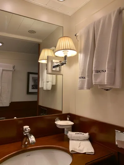 Iduna Yacht Photos Pics Bathroom interior of 1939 Feadship Classic Sailing Yacht with elegant fixtures and branded towels.
