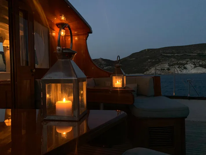 Iduna Yacht Photos Pics Candlelit evening on 1939 Feadship Classic Sailing Yacht, with serene ocean backdrop.