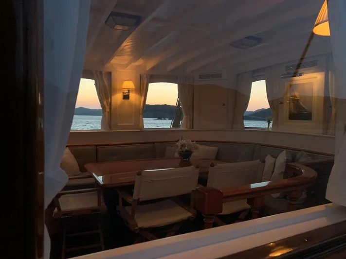 Iduna Yacht Photos Pics Interior of 1939 Feadship Classic Sailing Yacht with elegant dining area at sunset.