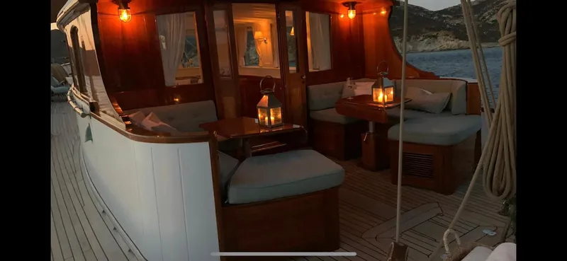 Iduna Yacht Photos Pics Classic 1939 Feadship sailing yacht with elegant wooden interior and ambient lighting at dusk.