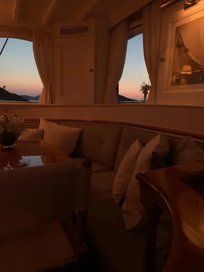 Iduna Yacht Photos Pics Interior of 1939 Feadship Classic Sailing Yacht at sunset, featuring elegant seating and decor.