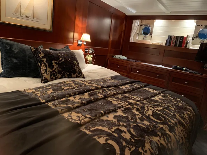 Iduna Yacht Photos Pics Luxurious cabin interior of 1939 Feadship Classic Sailing Yacht with elegant bedding and wood paneling.