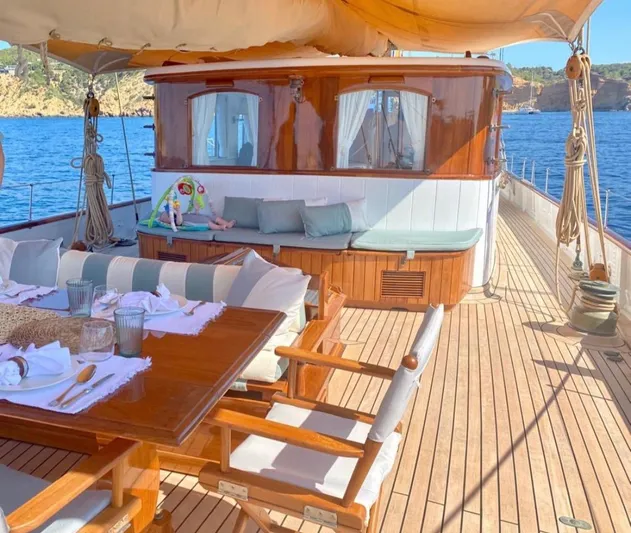 Iduna Yacht Photos Pics Classic 1939 Feadship sailing yacht with elegant wooden deck and outdoor dining area.