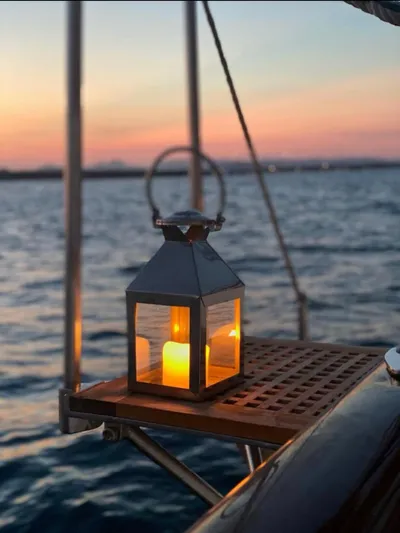 Iduna Yacht Photos Pics Candle lantern on 1939 Feadship Classic Sailing Yacht at sunset over the ocean.
