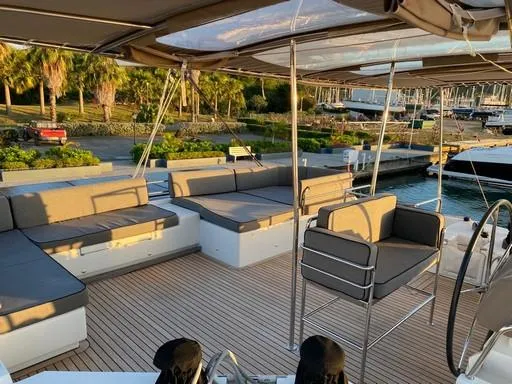 Recipe Yacht Photos Pics Luxurious Lagoon 560 yacht deck with seating, 2011 model, docked at marina with palm trees.