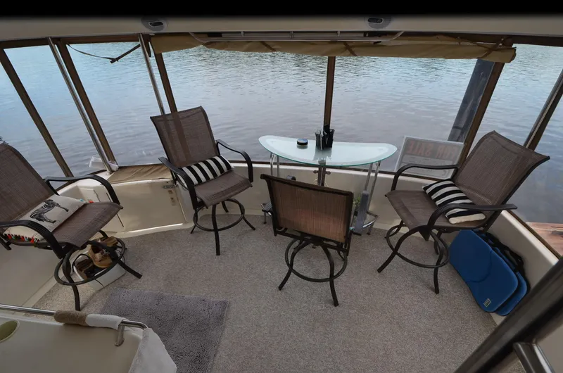 Escape Yacht Photos Pics 2000 Sea Ray 420 Aft Cabin interior with chairs and table overlooking water.