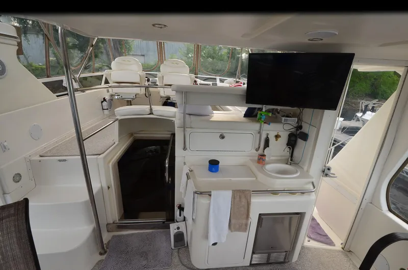 Escape Yacht Photos Pics Interior of 2000 Sea Ray 420 Aft Cabin yacht with helm, seating, and kitchenette.