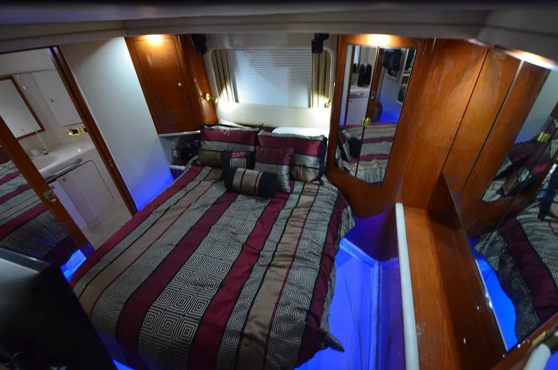 Escape Yacht Photos Pics Luxurious cabin interior of 2000 Sea Ray 420 Aft Cabin with elegant bedding and ambient lighting.
