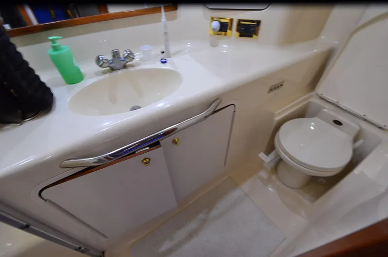 Escape Yacht Photos Pics Bathroom interior of 2000 Sea Ray 420 Aft Cabin yacht, featuring sink and toilet.