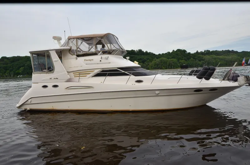 Escape Yacht Photos Pics 2000 Sea Ray 420 Aft Cabin yacht on calm water, surrounded by lush greenery.