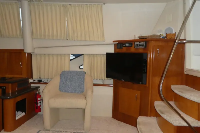  Yacht Photos Pics Interior of 2006 Carver 366 Motor Yacht with chair, TV, and stairs.