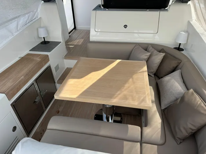  Yacht Photos Pics Interior of 2021 Bluegame BG42 yacht with cozy seating and wooden table.