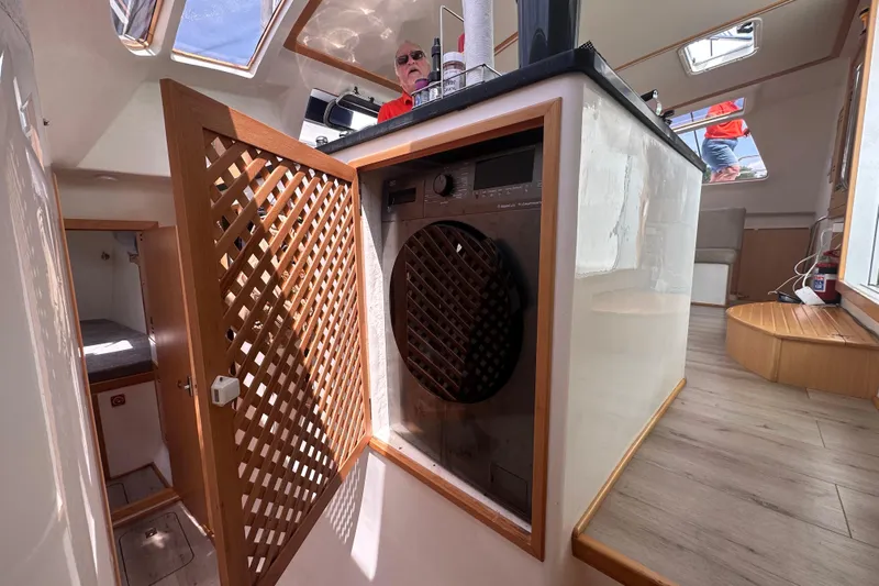 Waxy Yacht Photos Pics Interior of 2021 Celtic Yachts 40, featuring a built-in washing machine and wooden lattice door.