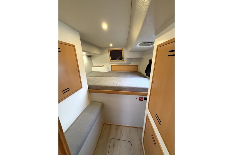 Waxy Yacht Photos Pics Interior cabin of 2021 Celtic Yachts 40, featuring cozy bed and wooden storage.