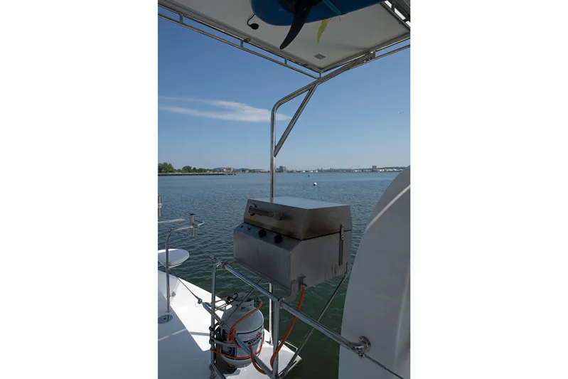 Waxy Yacht Photos Pics Celtic Yachts 40 (2021) with onboard grill, overlooking serene waters and distant skyline.