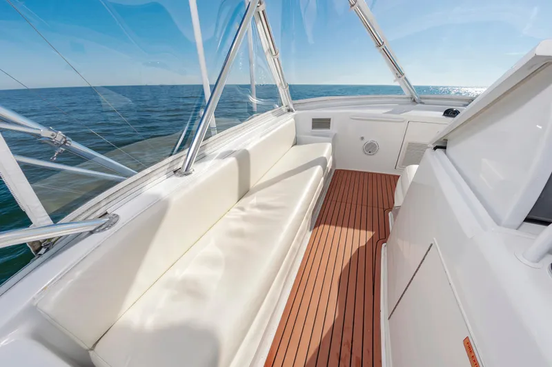 Sea Trader Yacht Photos Pics 2005 Hatteras 60 Convertible yacht with white seating and wooden deck, ocean view.