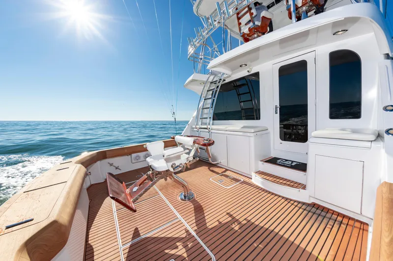 Sea Trader Yacht Photos Pics 2005 Hatteras 60 Convertible yacht deck with fishing chair, ocean view, and sunny sky.
