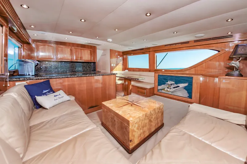 Sea Trader Yacht Photos Pics Luxurious interior of 2005 Hatteras 60 Convertible yacht with plush seating and wooden finishes.