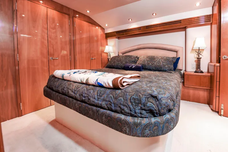 Sea Trader Yacht Photos Pics Luxurious bedroom interior of 2005 Hatteras 60 Convertible yacht with elegant wood finishes.