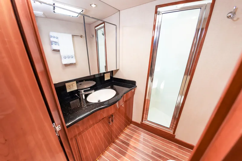 Sea Trader Yacht Photos Pics Luxurious bathroom in 2005 Hatteras 60 Convertible yacht with wood accents and modern fixtures.