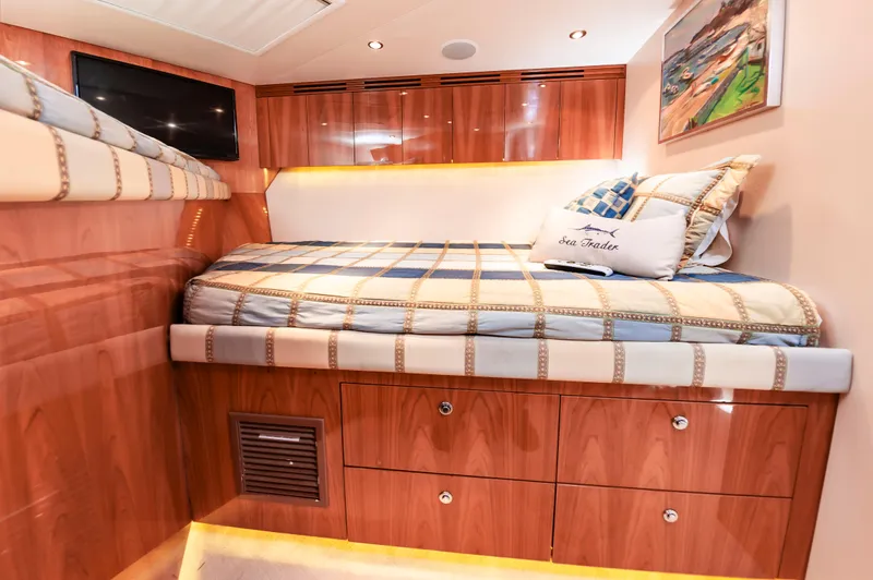 Sea Trader Yacht Photos Pics Luxurious cabin interior of 2005 Hatteras 60 Convertible yacht with wood finish and cozy bedding.