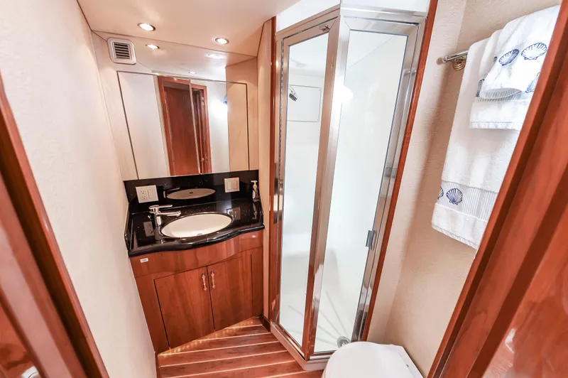 Sea Trader Yacht Photos Pics Luxurious bathroom in 2005 Hatteras 60 Convertible yacht with wood accents and modern fixtures.