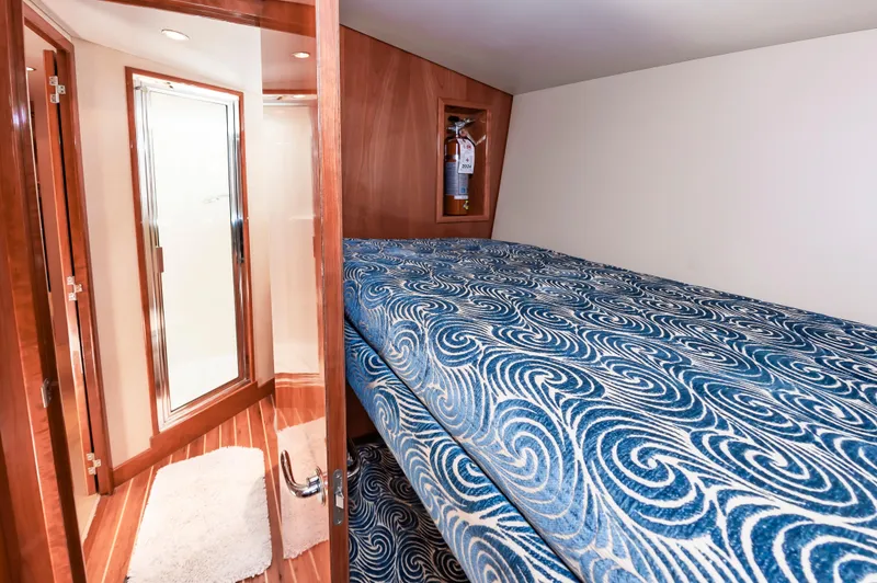 Sea Trader Yacht Photos Pics Interior cabin of 2005 Hatteras 60 Convertible yacht with blue patterned bedding.