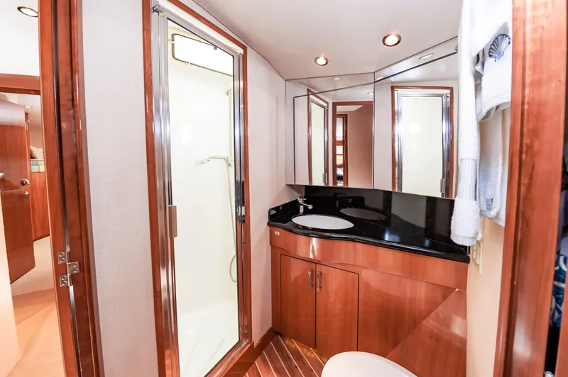 Sea Trader Yacht Photos Pics Luxurious bathroom in 2005 Hatteras 60 Convertible yacht with modern fixtures and wood accents.