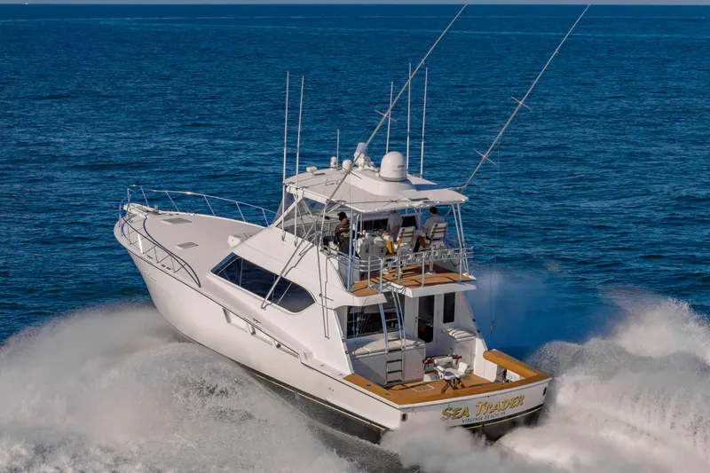 Sea Trader Yacht Photos Pics 2005 Hatteras 60 Convertible yacht cruising on open sea, creating waves.