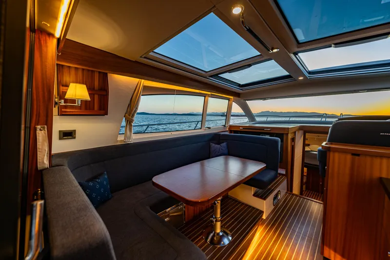 Treasure State Yacht Photos Pics Luxurious interior of 2022 Nimbus 405 Coup&eacute; yacht with panoramic windows and elegant seating.