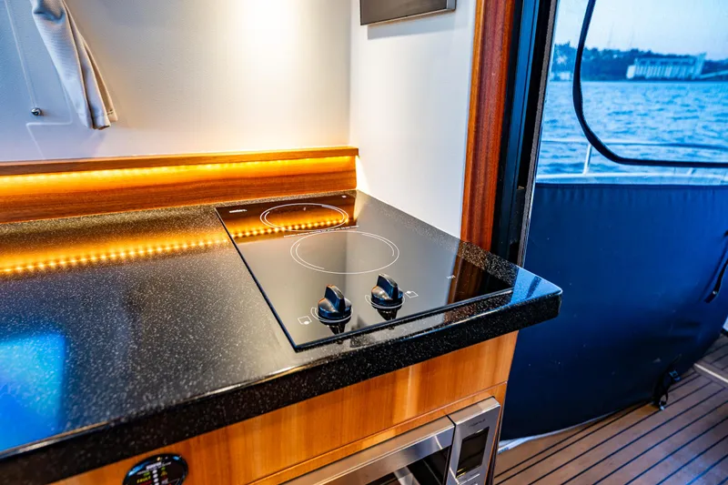 Treasure State Yacht Photos Pics Modern kitchen in 2022 Nimbus 405 Coup&eacute; yacht with sleek stovetop and ocean view.