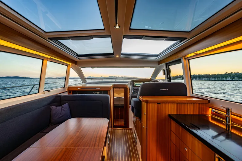 Treasure State Yacht Photos Pics Luxurious interior of 2022 Nimbus 405 Coup&eacute; yacht with panoramic windows and elegant wood finishes.