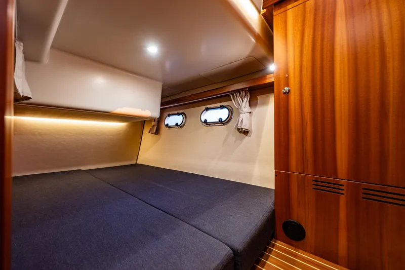 Treasure State Yacht Photos Pics Luxurious cabin interior of 2022 Nimbus 405 Coup&eacute; yacht with wood paneling and cozy bedding.