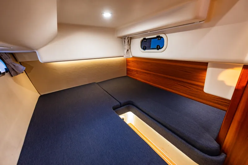 Treasure State Yacht Photos Pics Interior cabin of 2022 Nimbus 405 Coup&eacute; with cozy bedding and wooden accents.