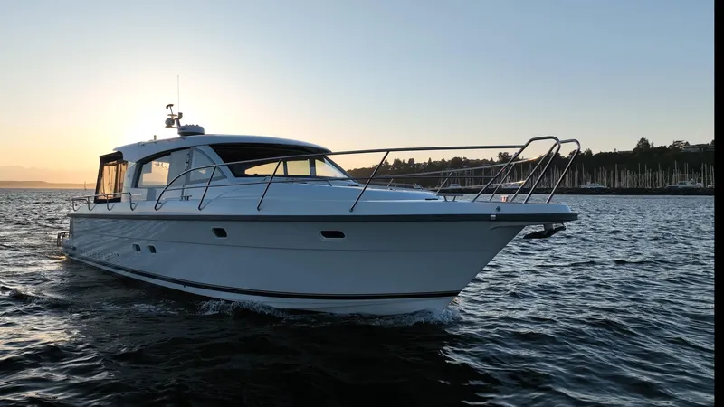 Treasure State Yacht Photos Pics 2022 Nimbus 405 Coup&eacute; yacht cruising on water at sunset.