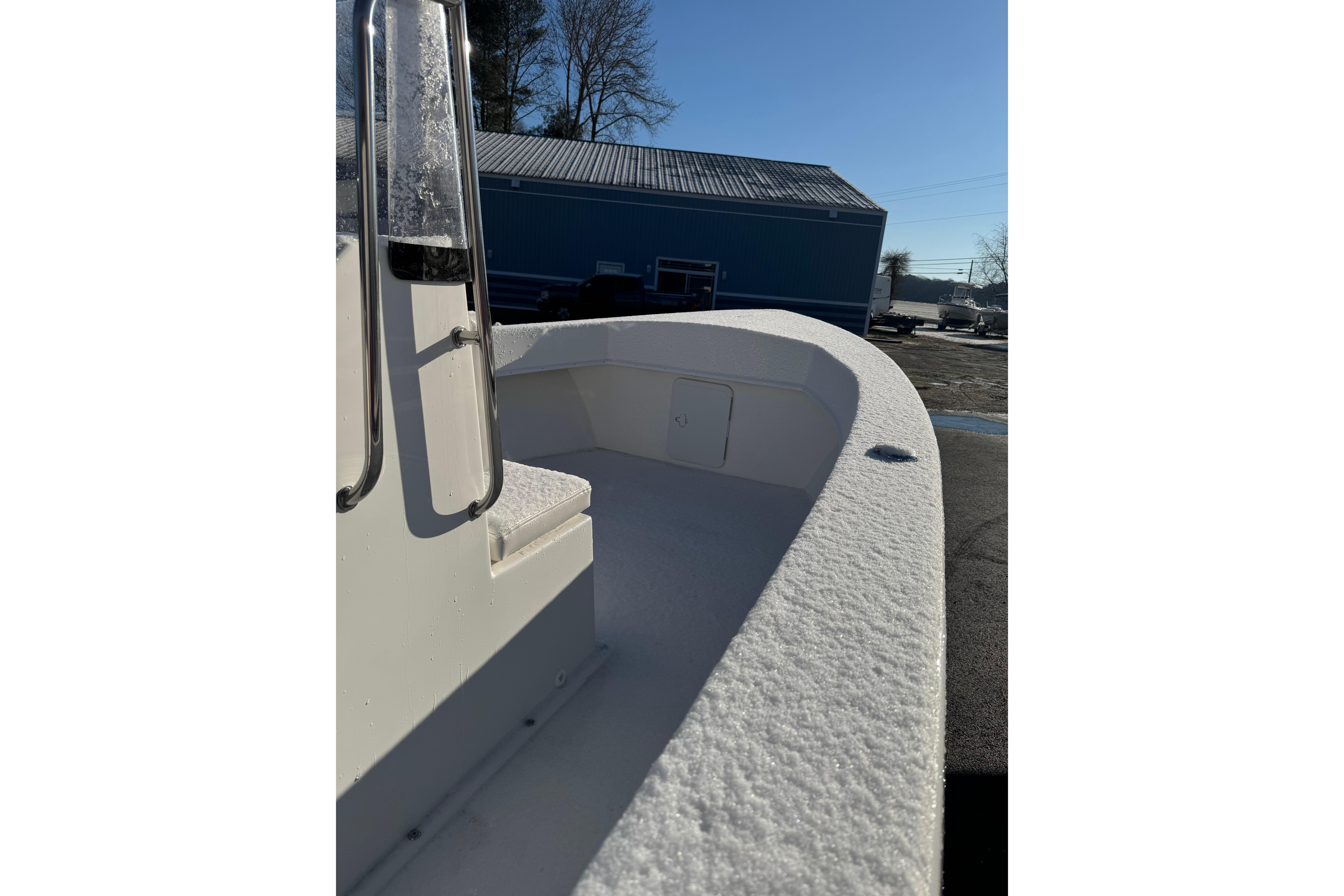 2026 C-Hawk 18 Center Console boat with snow-covered deck, parked outdoors.