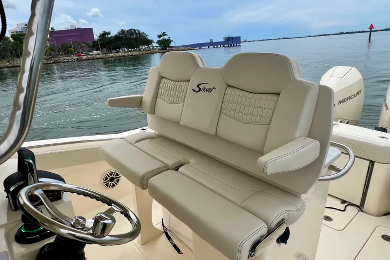  Yacht Photos Pics 2026 Scout 288 LXF boat interior with luxurious seating and steering wheel, docked by the water.