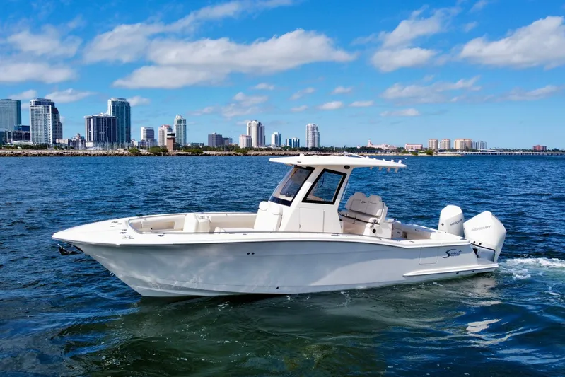  Yacht Photos Pics 2026 Scout 288 LXF boat cruising on water with city skyline in background.