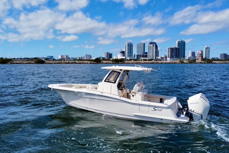  Yacht Photos Pics 2026 Scout 288 LXF boat cruising on water with city skyline in background.