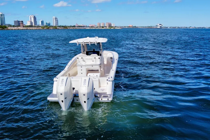  Yacht Photos Pics 2026 Scout 288 LXF boat cruising on open water near city skyline.