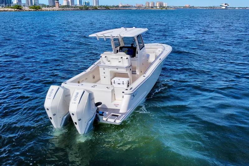  Yacht Photos Pics 2026 Scout 288 LXF boat cruising on open water with city skyline in background.