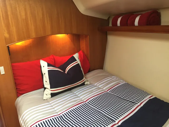 Sapphire Yacht Photos Pics Cozy cabin interior of 2007 Hunter 41 Deck Salon with striped bedding and warm lighting.