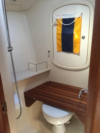 Sapphire Yacht Photos Pics 2007 Hunter 41 Deck Salon bathroom with wooden bench, shower, and nautical decor.