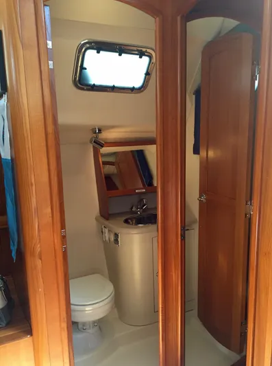 Sapphire Yacht Photos Pics 2007 Hunter 41 Deck Salon bathroom with wooden cabinetry and porthole window.