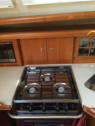 Sapphire Yacht Photos Pics 2007 Hunter 41 Deck Salon kitchen with stove, microwave, and wooden cabinetry.